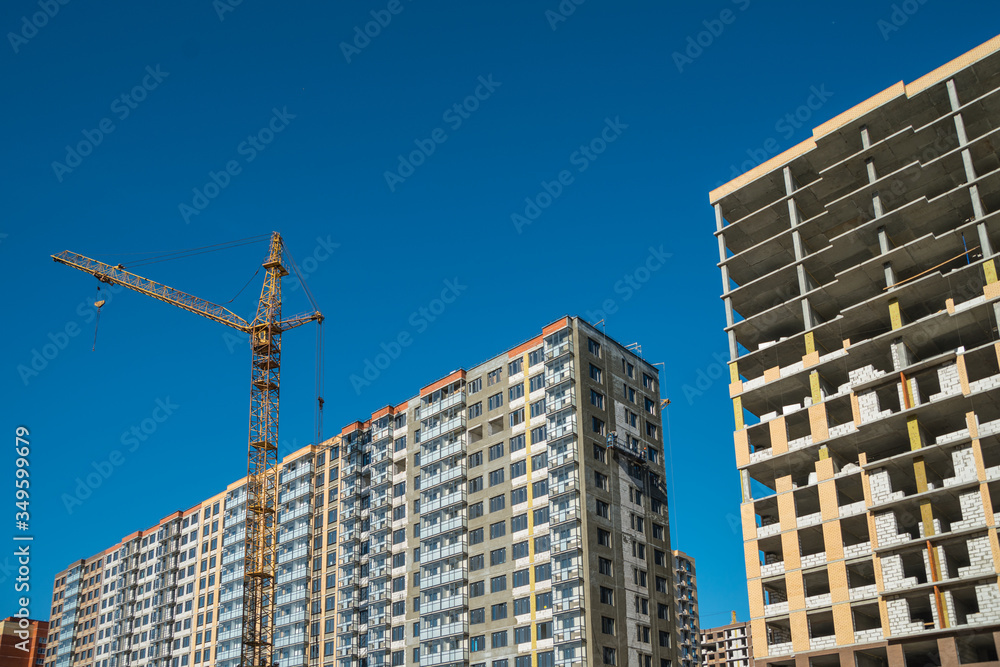 Construction crane near new built house. Construction and developing Construction crane near new built house. Construction and developing