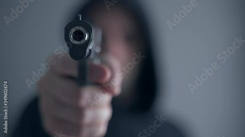 Criminal aiming gun camera, threatening burglar at victim