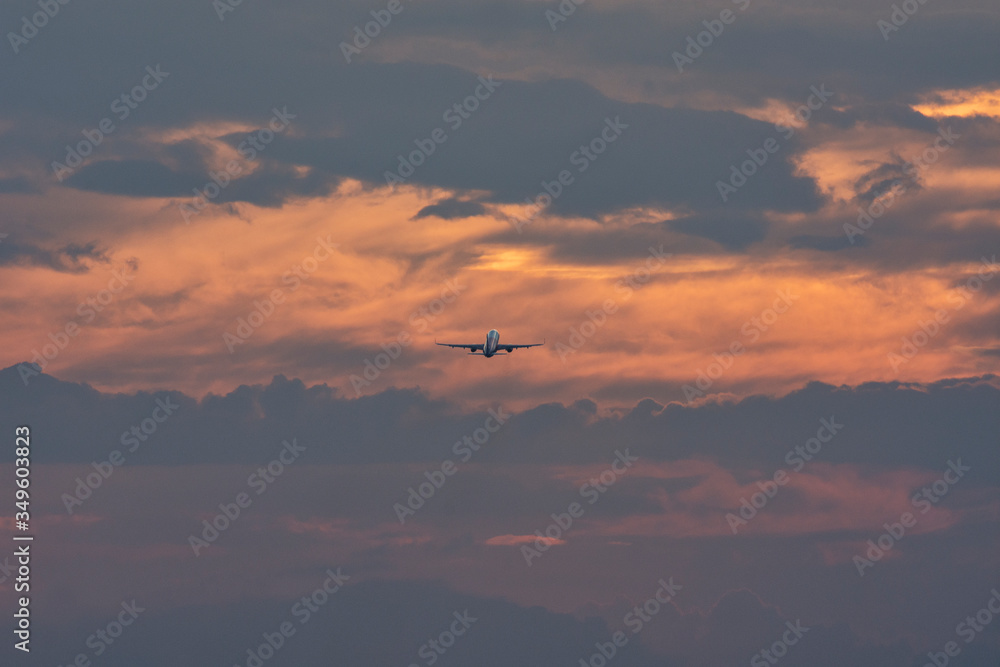 Taking off airplane at colorful sunset. Silhouette, selective focus. Landscape, background.