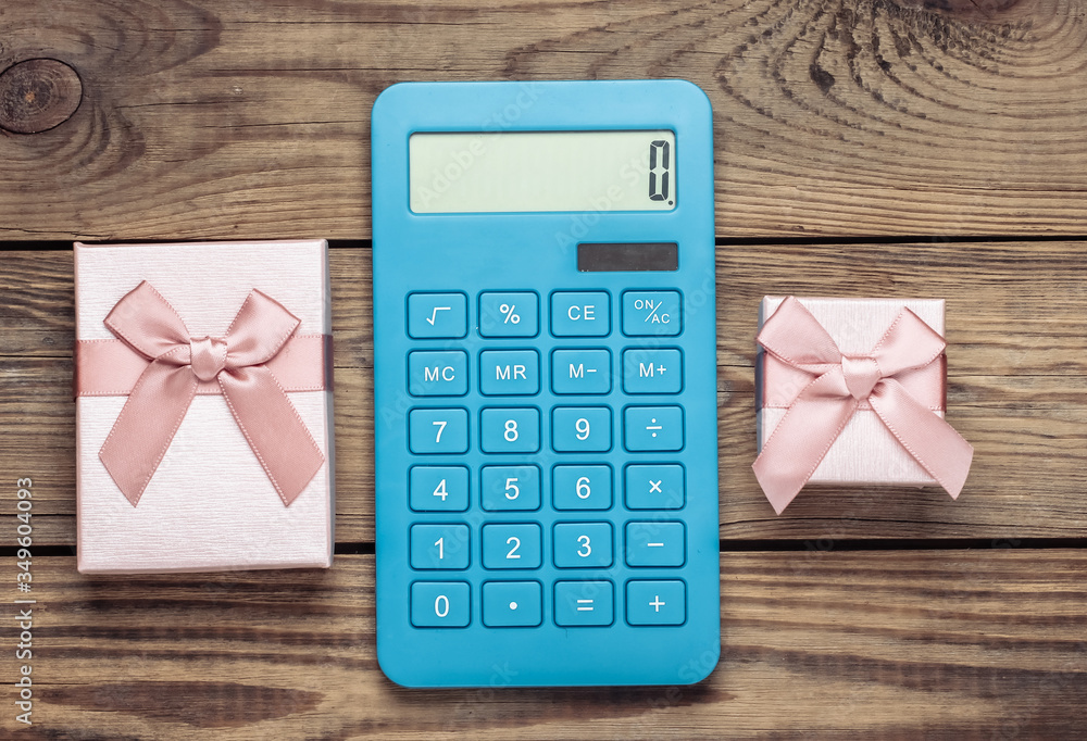 Calculator with a gift boxes on a wooden background. Top view Calculator with a gift boxes on a wooden background. Top view