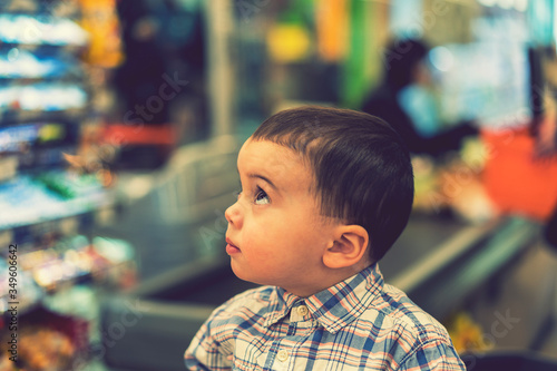 The little boy on a background of cash in a supermarket. toned