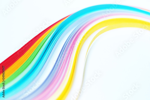 Colored strips of paper for quilling, rainbow stretches into the distance, selective focus