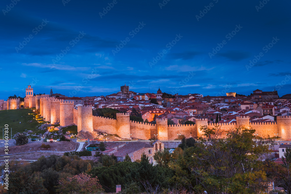 View from Cuatro Postes over the medieval city walls of Avila at dusk. Avila, Castilla y Leon, Spain, Europe