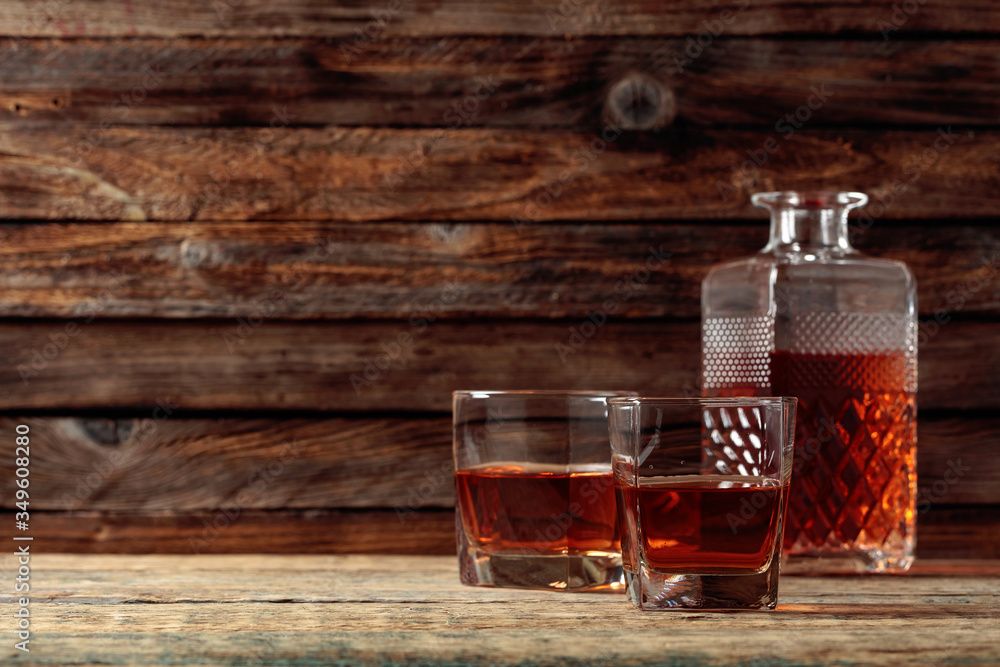 Glasses and decanter of whiskey on a old wooden table. Glasses and decanter of whiskey on a old wooden table.
