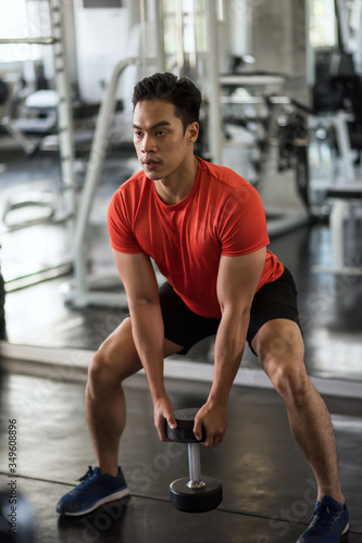 Muscle man exercise biceps in gym