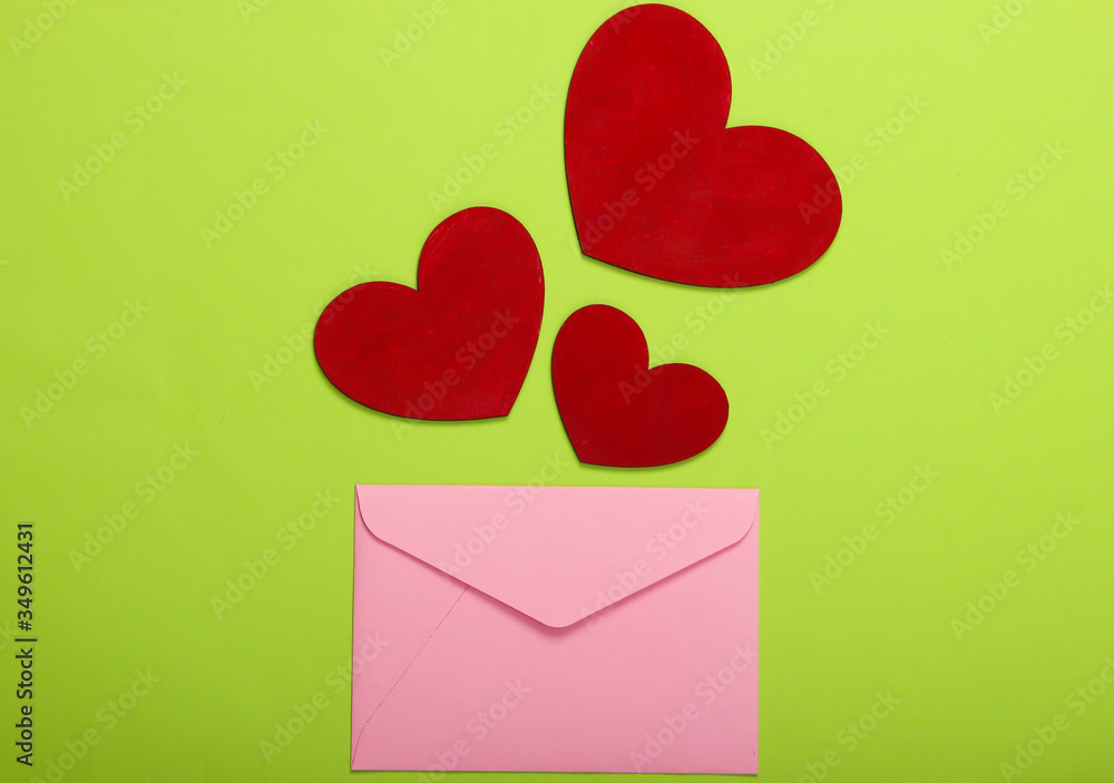 Envelope with hearts (valentines) on a green background. Valentine's Day. Top view Envelope with hearts (valentines) on a green background. Valentine's Day. Top view