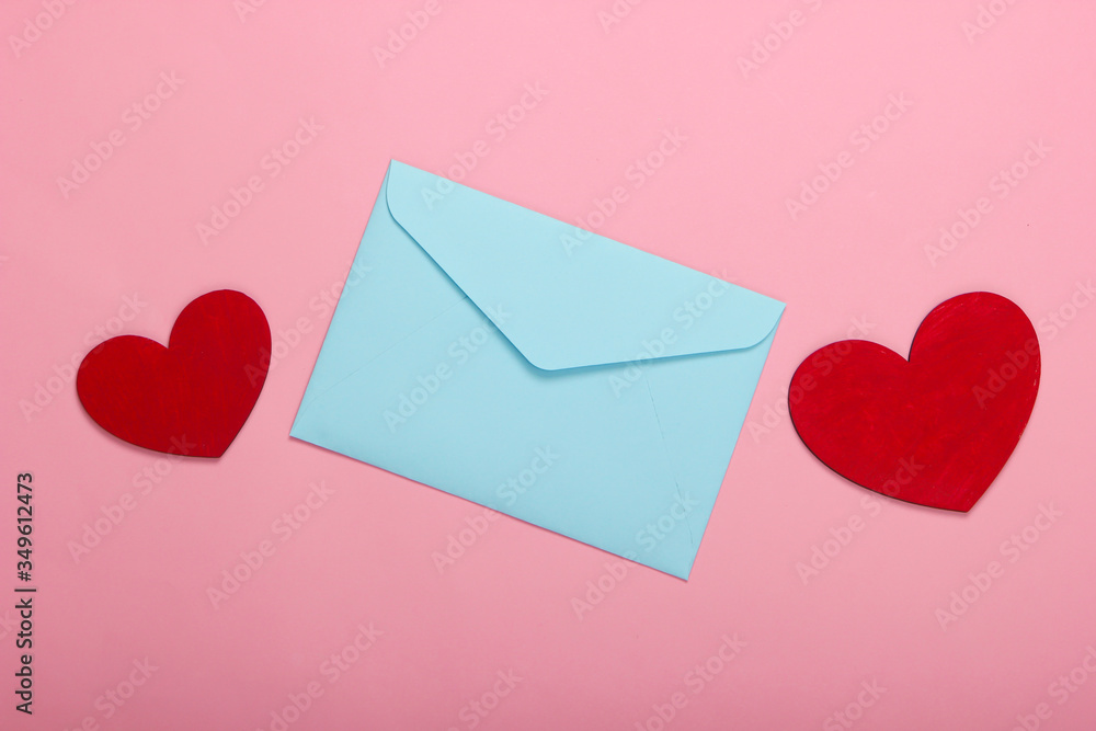 Envelope with red hearts (valentines) on pink pastel background. Valentine's Day. Top view