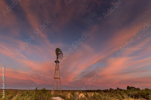 Canvas Print landscape image in the karoo, South Africa with windmill at sunset