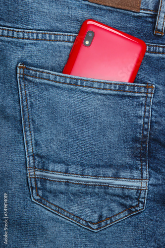 Red smartphone in back jeans pocket photo