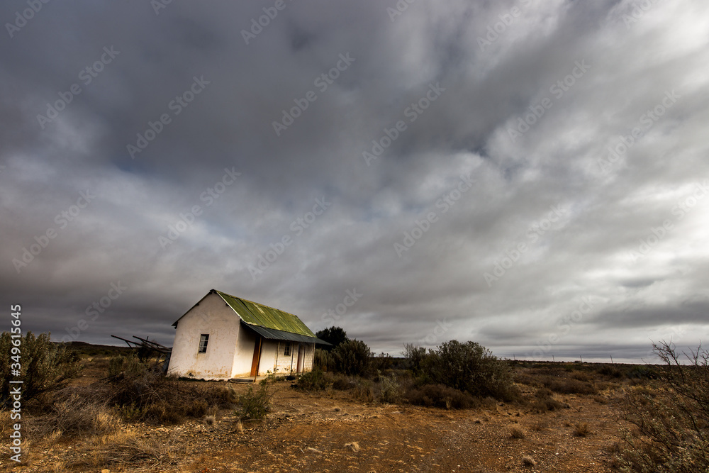 abandoned house in the Karoo with stormy clouds