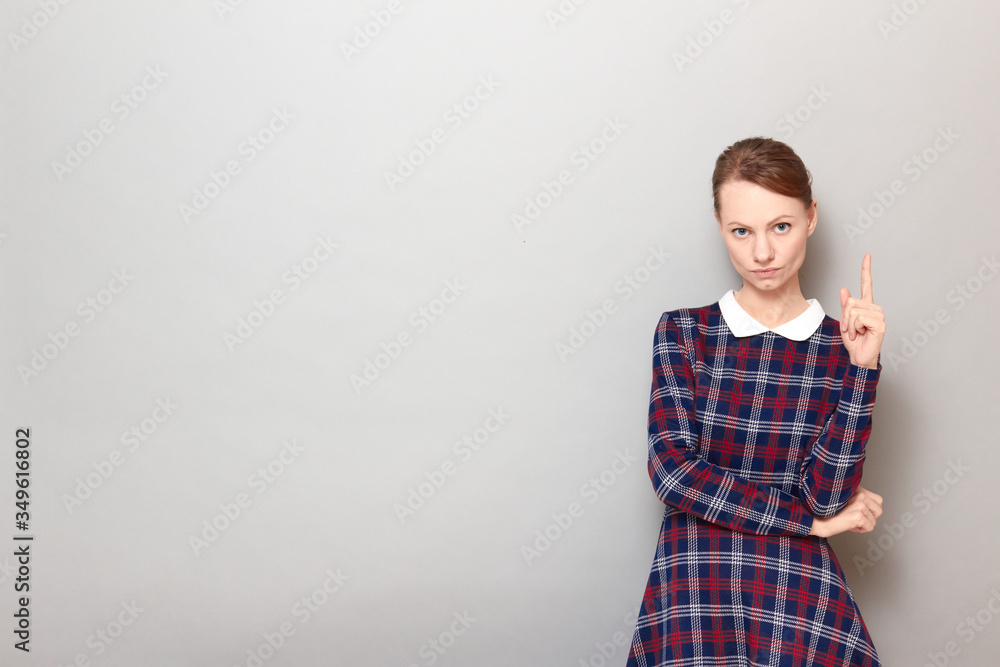 Portrait of serious focused girl pointing up with index finger Portrait of serious focused girl pointing up with index finger