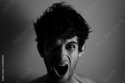 Cry shocked angry man curly hair shadows light black and white