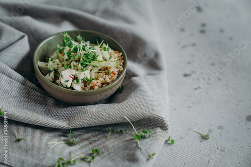 salad with quinoa, microgreens, cucumber, cottage cheese searved on gray background with linen napkin. clean eating for immunity copyspace