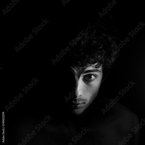 Face young man black background apparition