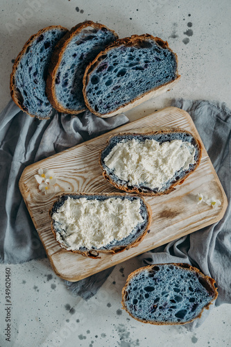 Home made blue bread on a wooden cutting board with curd cheese and ricotta