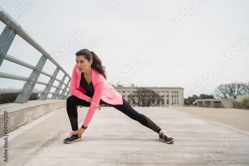 Athletic woman stretching legs before exercise.