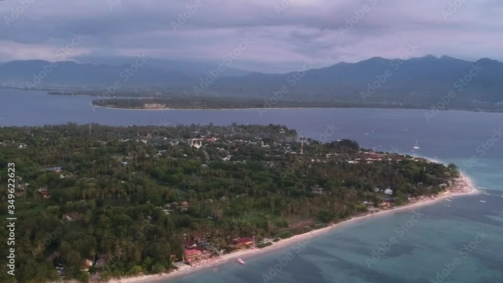 flight over gili air in the evening a mosque and mountains are visible across the ocean flight over gili air in the evening a mosque and mountains are visible across the ocean