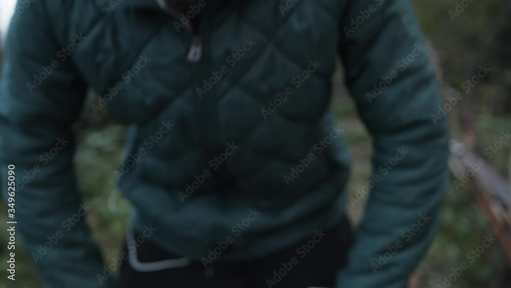 Man doing morning exercise in forest and taking a break for catch his breath. Listening music while doing exercise. Morning exercise concept. Slow motion, 4k. Man doing morning exercise in forest and taking a break for catch his breath. Listening music while doing exercise. Morning exercise concept. Slow motion, 4k.