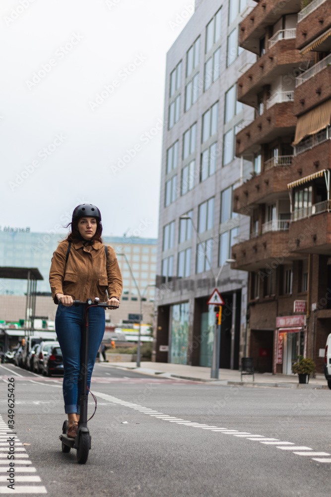 Woman with helmet exploring the city on a electric scooter