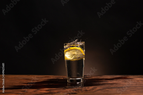 Obraz na płótnie lemon in glass of water on black background w salonie