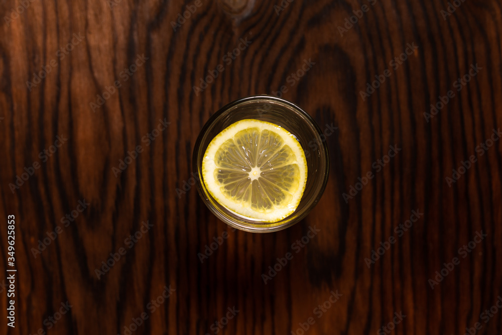 lemon in glass of water on black background