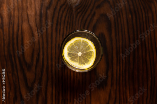 Obraz na płótnie lemon in glass of water on black background w salonie
