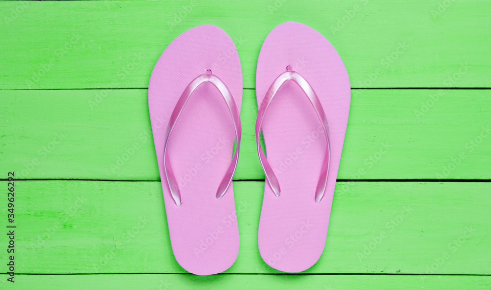 Tropical beach lifestyle. Flip flops on green wooden background. Summer background. Top view Tropical beach lifestyle. Flip flops on green wooden background. Summer background. Top view