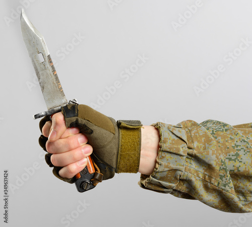 male in russian mechanized infantry uniform holding a knife isolated on grey background.