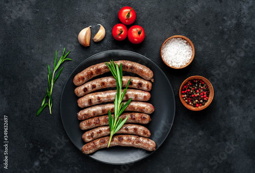 grilled sausages with ingredients on a plate on a stone background