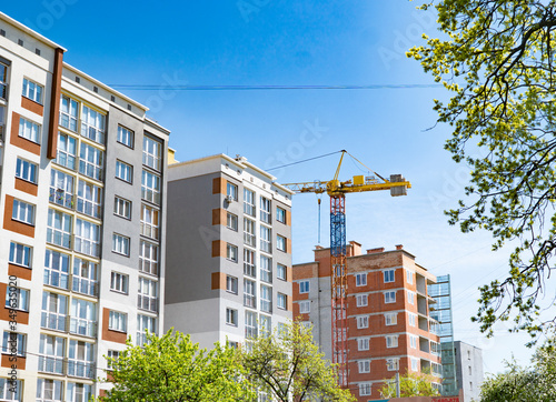 high-rise crane on the background of built houses