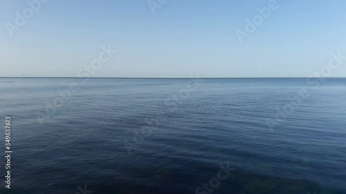 Blue sky blue sea with dolphins on the horizon photo