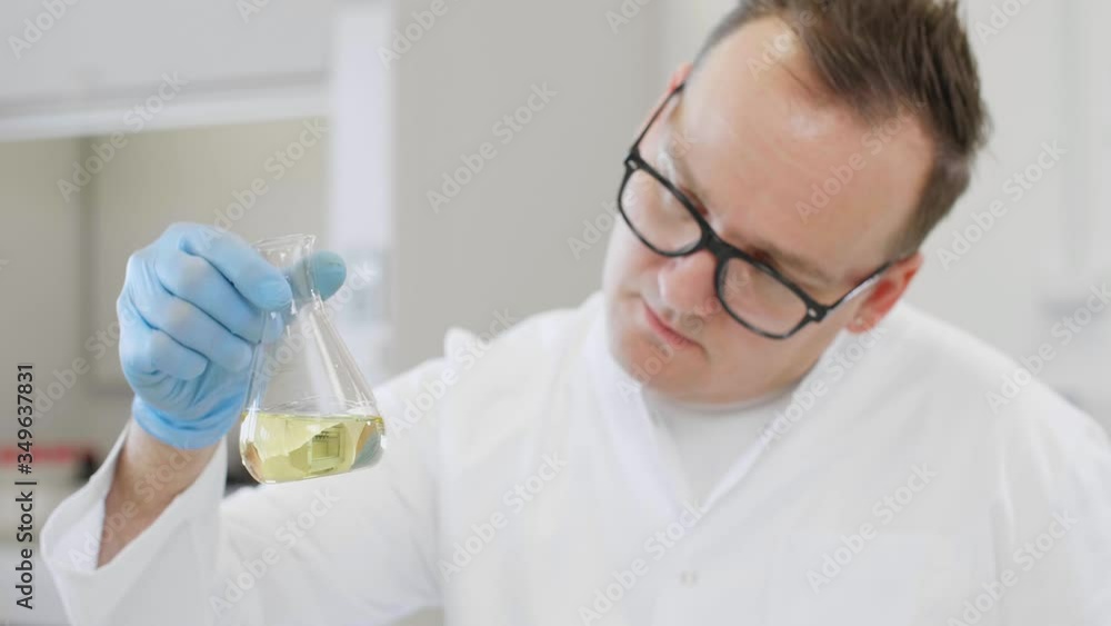 Close up of chemist working with hemp CBD oil and tablet in laboratory