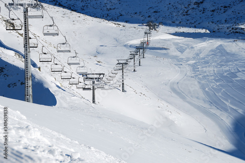 Panorama of ski resort, slope, people on the ski lift, skiers on the piste among white snow pine trees © Владимир Лис