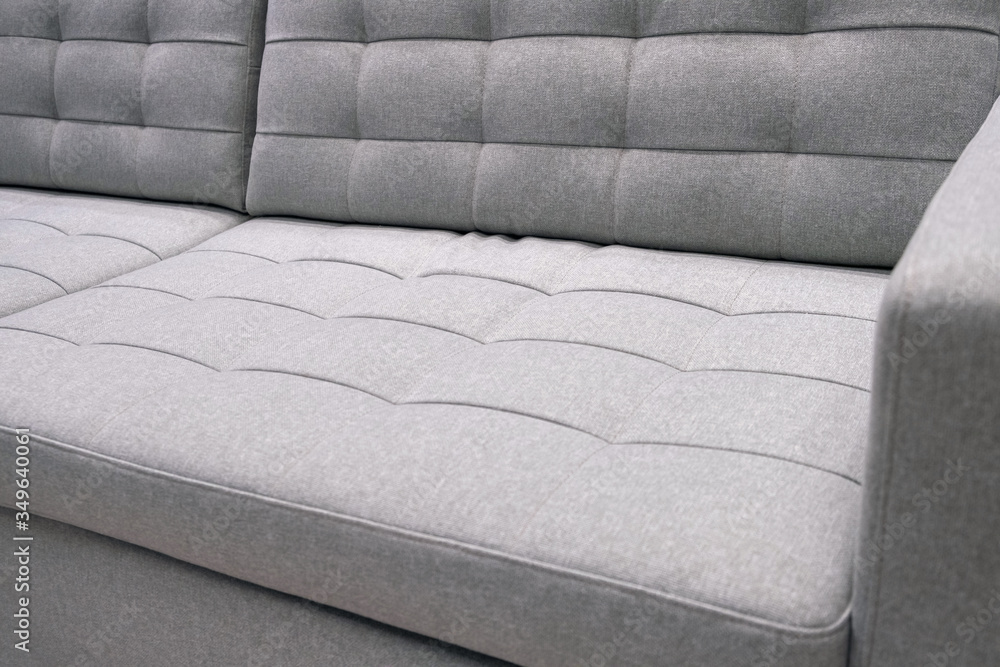 Obraz premium Grey textile modern sofa front view. Close up