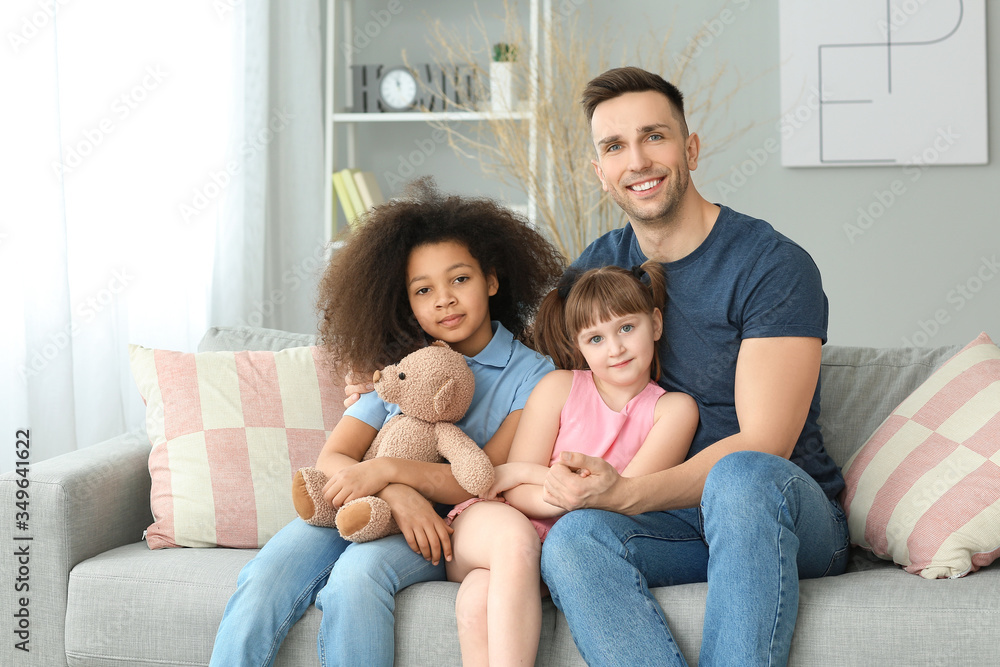 Happy man with little adopted children at home Happy man with little adopted children at home