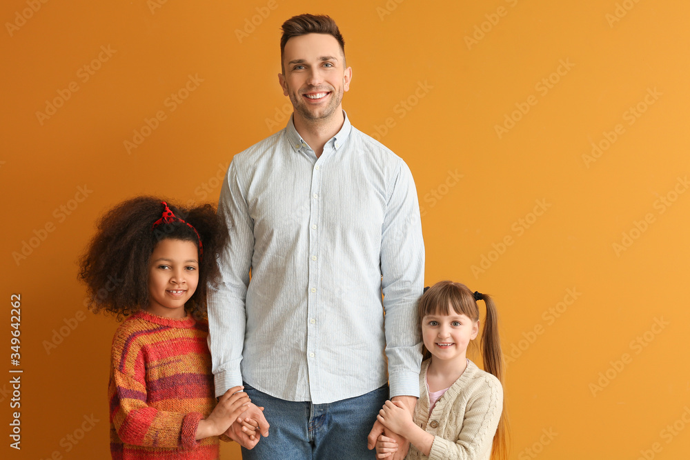 Obraz premium Happy man with little adopted children on color background