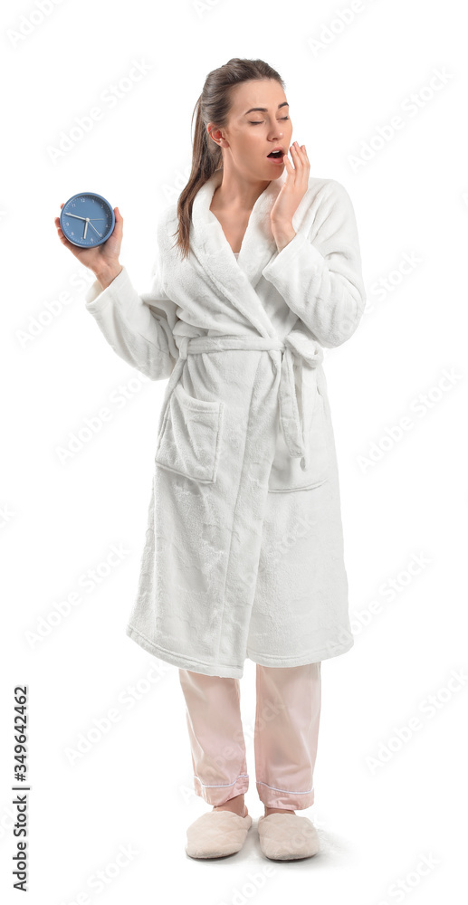 Tired young woman with alarm clock on white background Tired young woman with alarm clock on white background