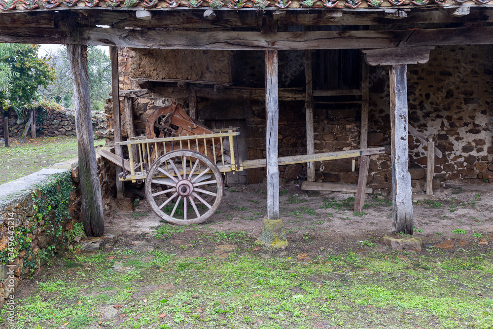 Obraz premium Vintage wooden carriage with old tillage machinery on top