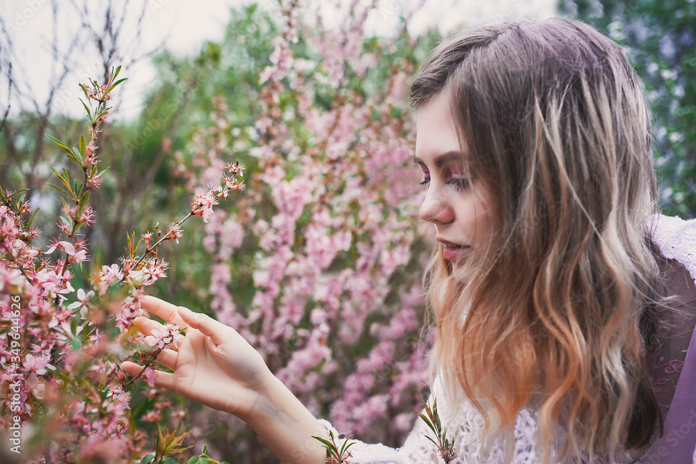 Girl in a delicate dress with mehendi on the body, in flowering almonds Girl in a delicate dress with mehendi on the body, in flowering almonds