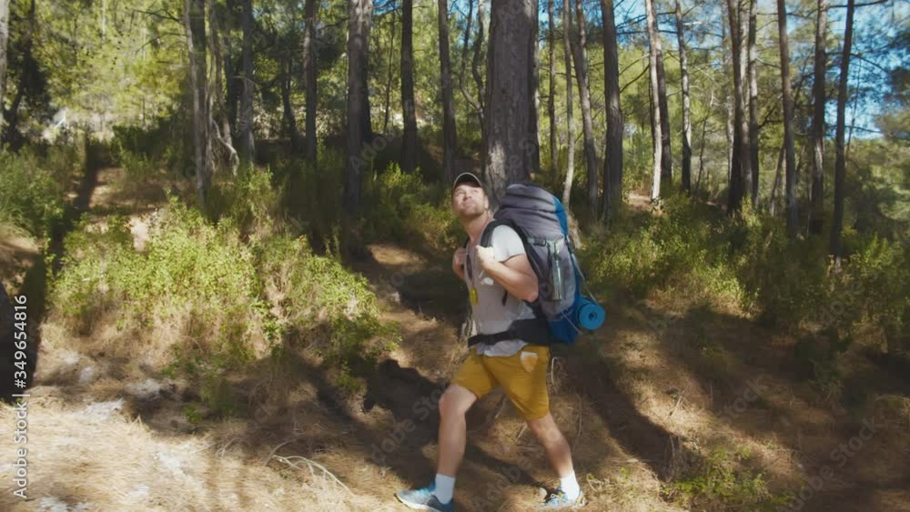 Cheerful man backpacker enjoying trekking in forest or park Cheerful man backpacker enjoying trekking in forest or park