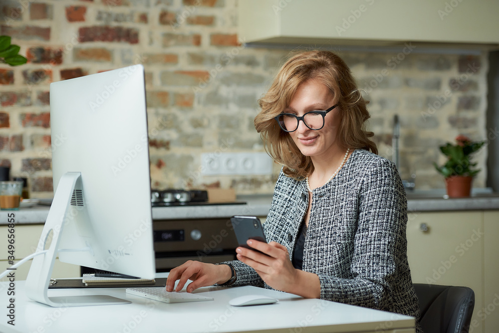 A woman in glasses works remotely on a desktop computer in her studio. A boss distracted by a smartphone during a video conference at home. A happy professor uses a cellphone before an online lecture.