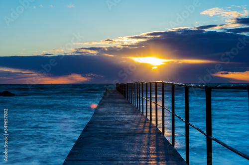 Cloudy spring sunset over ocean and jetty, Sweden
