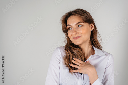 Young woman isolated on white background. Casual woman smiling looking to the side in light white t-shirt