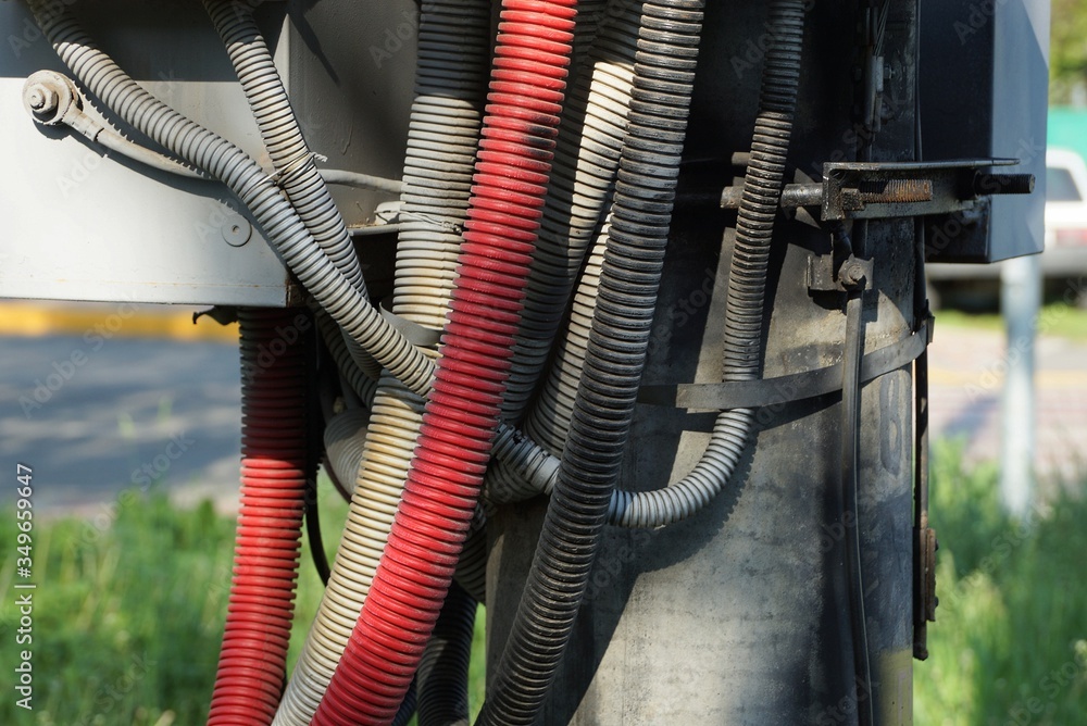 gray red plastic hoses with electrical cables on a concrete pillar gray red plastic hoses with electrical cables on a concrete pillar