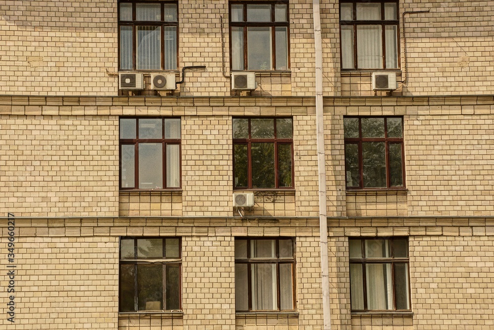 Fototapeta premium texture of a row of windows on a brown brick wall of a large building