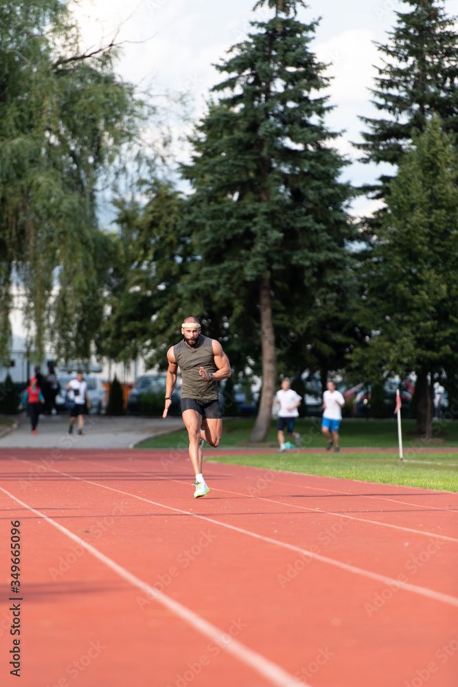 Young Male Athlete Running on Track