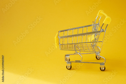 A food cart on a yellow background. Online shopping. A place for text.
