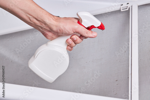 cleaning and washing dusty mosquito net screen for window. housework concept. photo