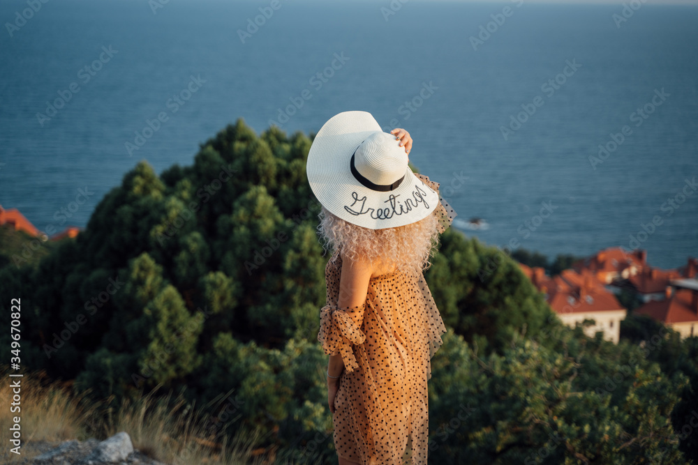 Girl in a white hat against the sea