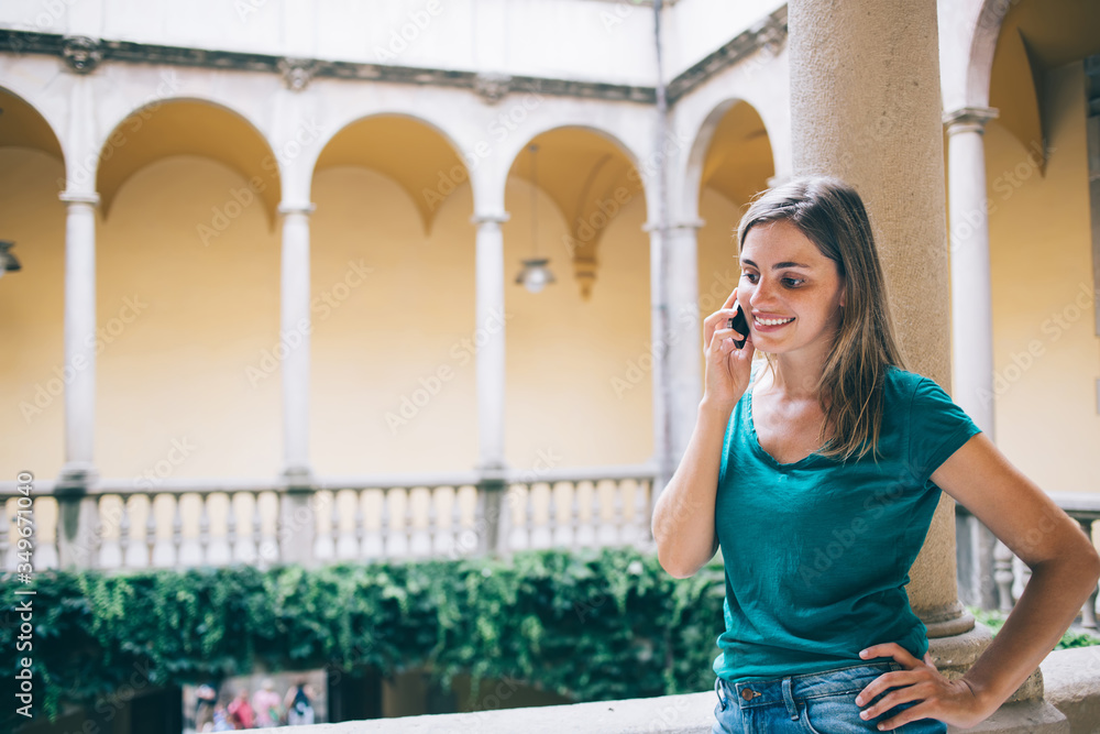 Smiling traveling woman speaking on smartphone